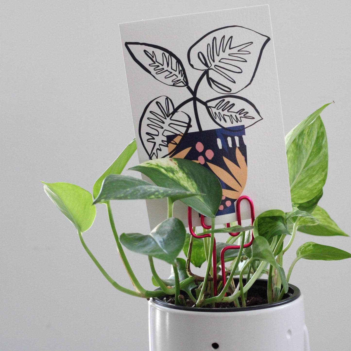 Decorative cactus-shaped plant stake handcrafted from bright pink aluminium with an example gift card; doubles as a plant support and a unique gift card holder—perfect as a sustainable plant gift idea.