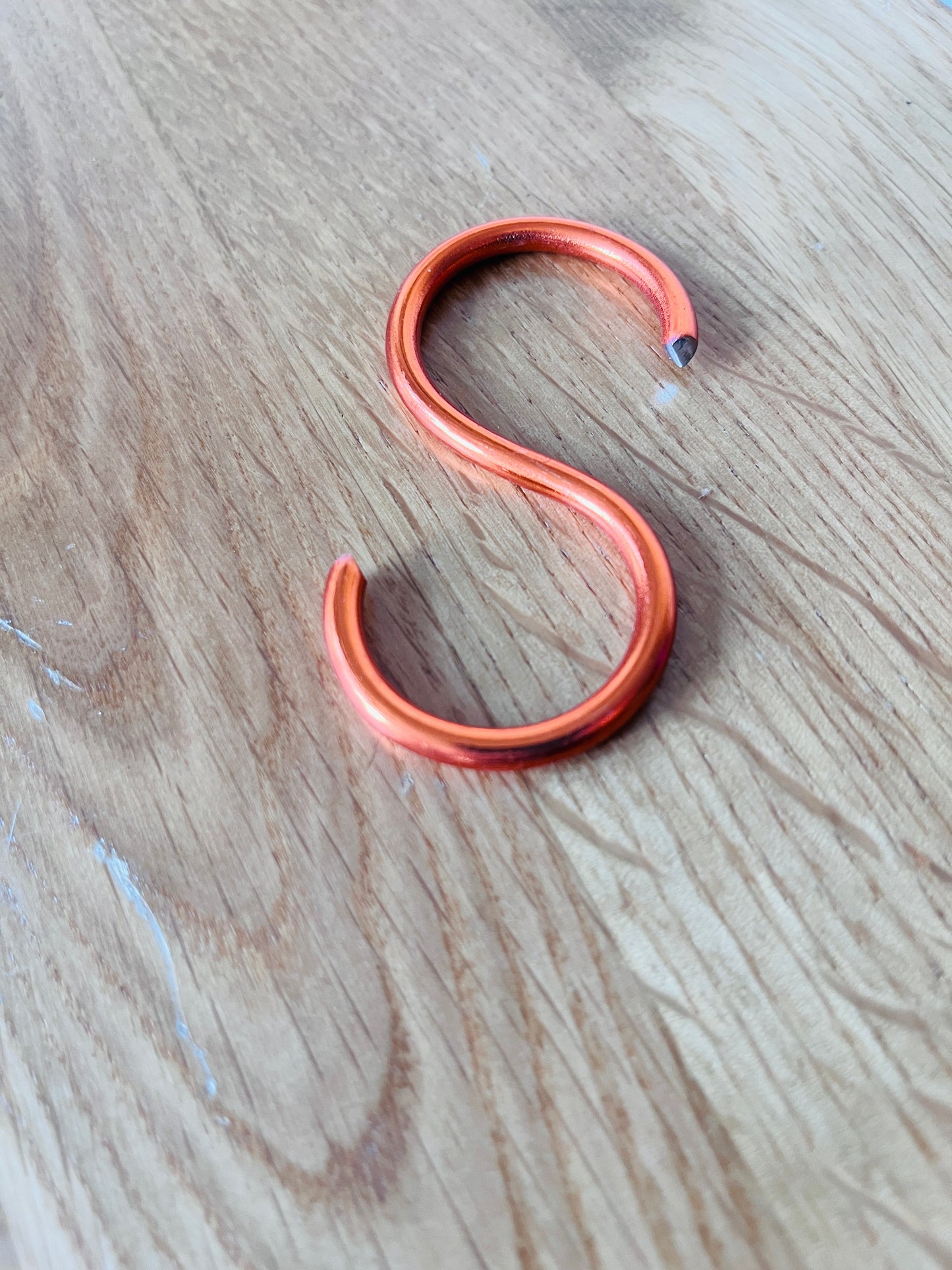 Copper hook on a wooden surface