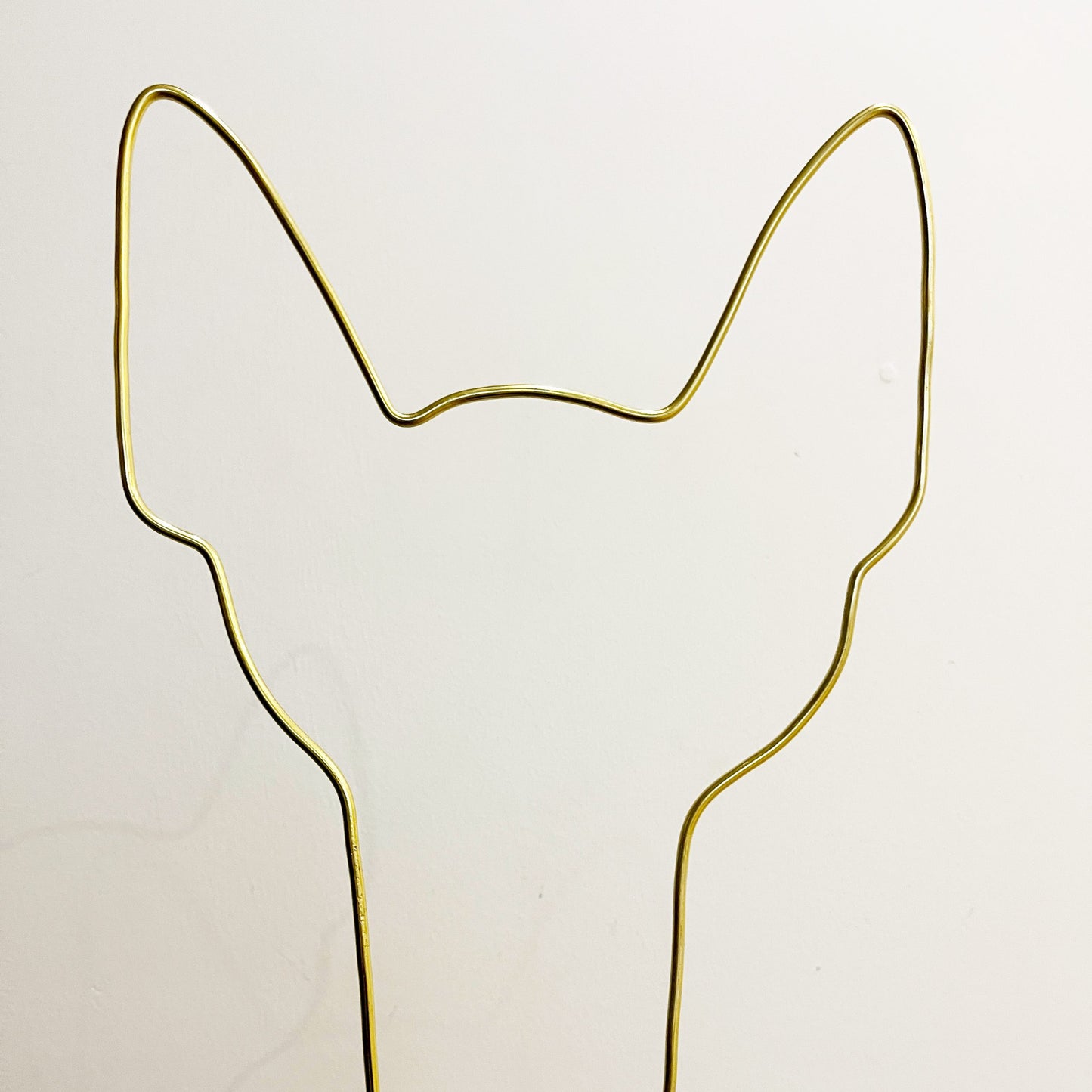 Dog ear-shaped plant trellis handcrafted from gold aluminium wire, shown against a neutral background—designed to support small climbing houseplants.