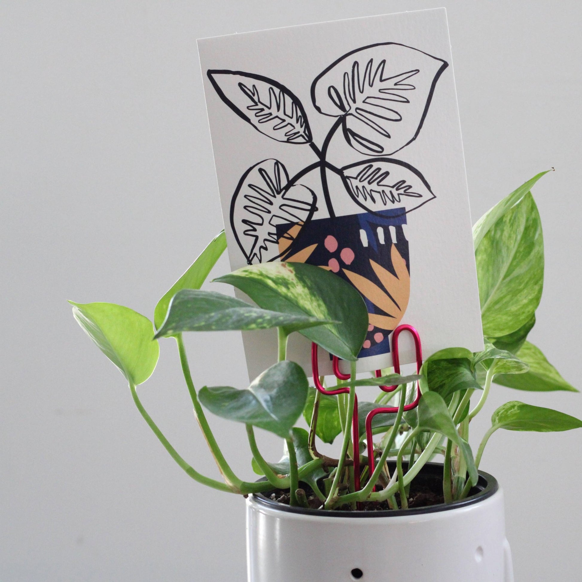 Decorative cactus-shaped plant stake handcrafted from bright pink aluminium with an example gift card; doubles as a plant support and a unique gift card holder—perfect as a sustainable plant gift idea.