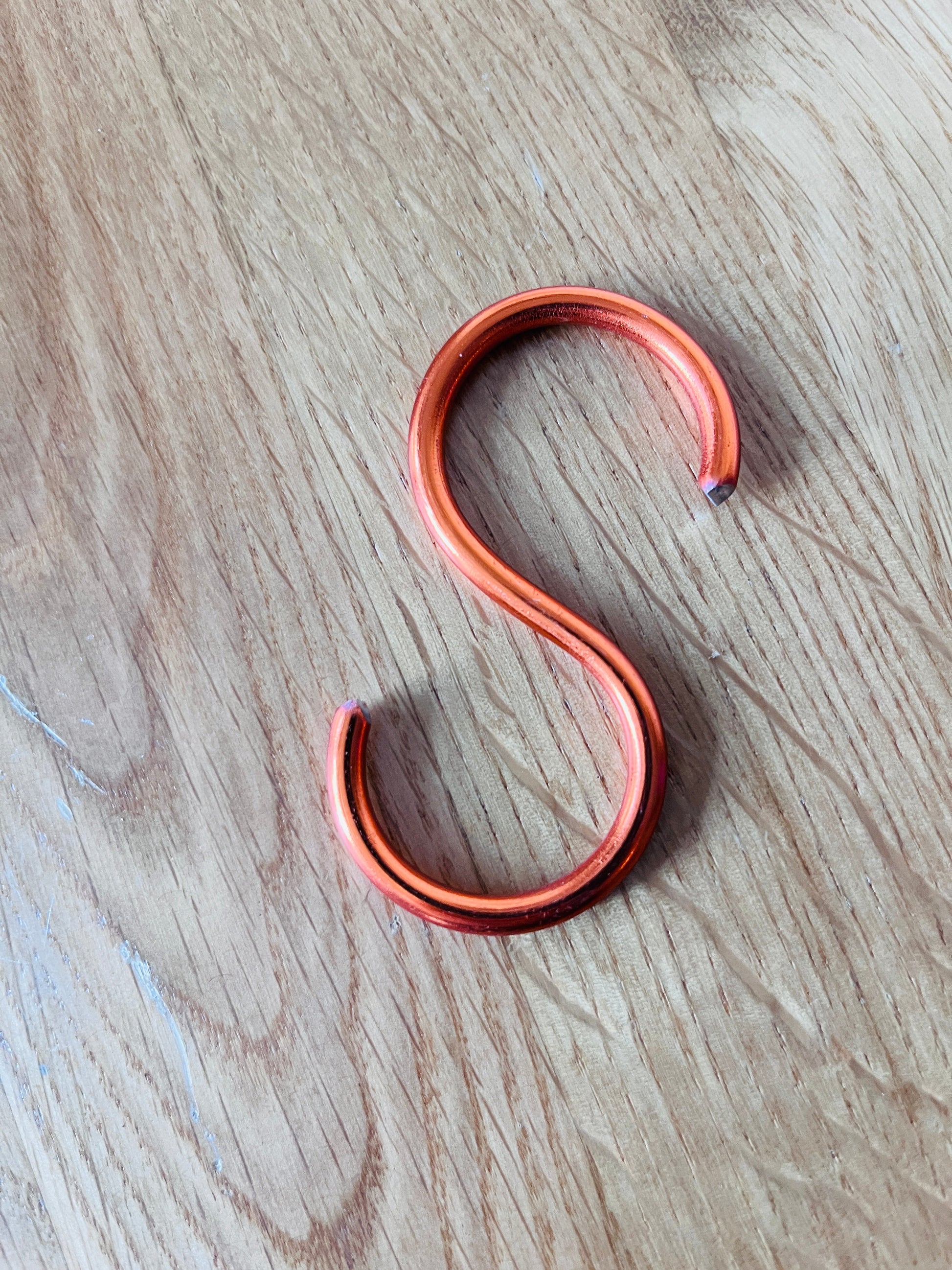 Copper hook on a wooden surface