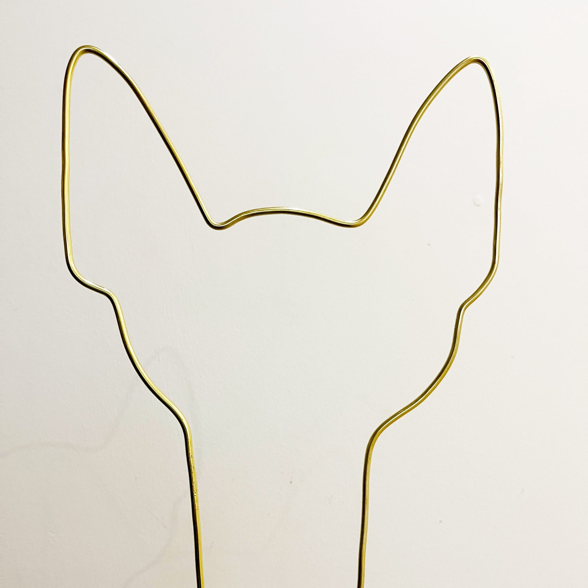 Dog ear-shaped plant trellis handcrafted from gold aluminium wire, shown against a neutral background—designed to support small climbing houseplants.